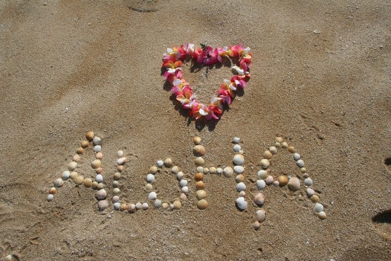 USA Reisen - Das Wort Aloha steht im Sand von Oahu, Hawaii.