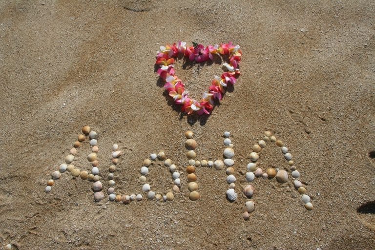 USA Reisen - Das Wort Aloha steht im Sand von Oahu, Hawaii.